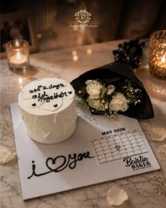 Minimal white anniversary cake with roses and personalized calendar design