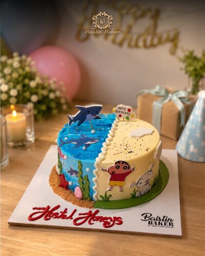 Ocean and cartoon themed birthday cake with shark toppers and colorful character decorations