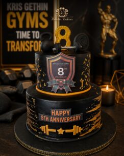 Black and gold gym anniversary cake featuring dumbbells, kettlebell, fitness decorations, and customized anniversary design.