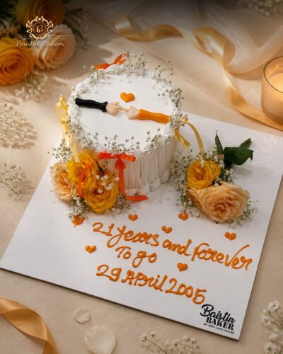 Romantic anniversary cake with floral decorations, ribbon accents, symbolic hand design, and elegant customized anniversary message.