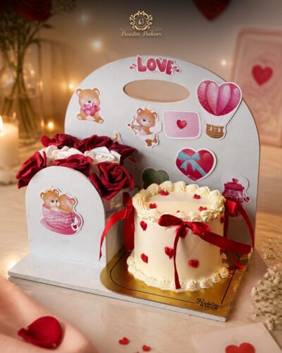 Romantic cake and rose bouquet combo with love-themed decorations and red ribbon accents.