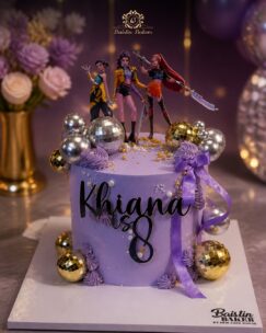 Customized purple birthday cake featuring gaming princess figurines and metallic decorative accents.