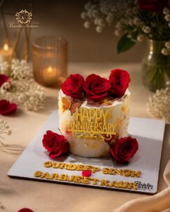 Elegant anniversary cake decorated with red roses and golden anniversary topper.