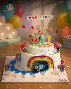 Cocomelon first birthday cake with rainbow and train theme by Baistin Bakers Jalandhar